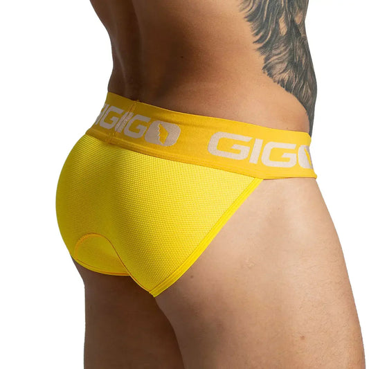 Side view of a model wearing a yellow Gigo Colors brief with a matching branded waistband.