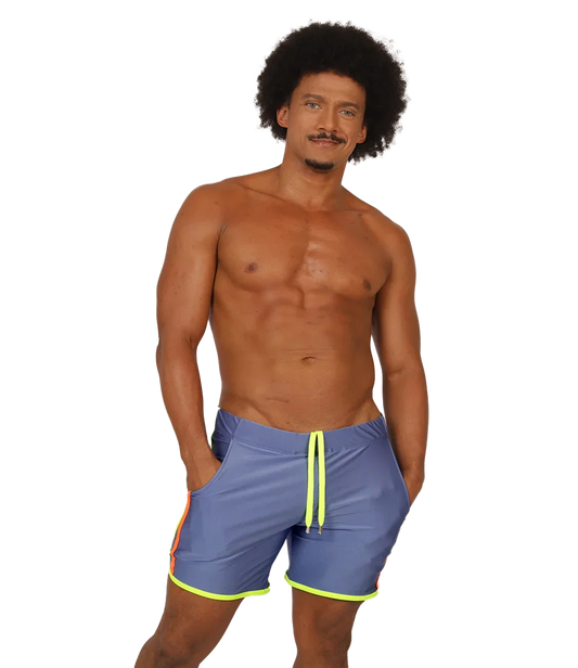 Model wearing blue Gigo shorts with a neon yellow drawstring and hem trim and an orange side accent.