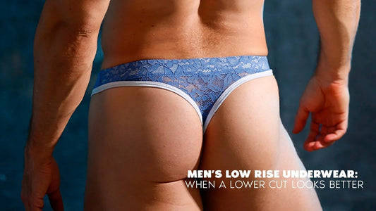 Back view of a model wearing a low rise blue lace brief with white trim against a dark blue background.